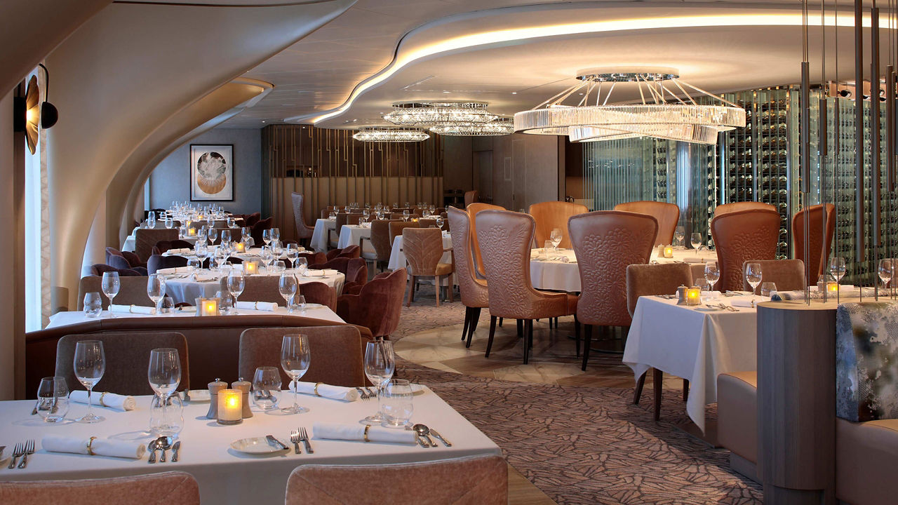 An upscale restaurant with white table linens and chandeliers