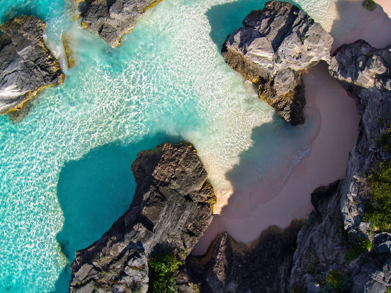 Walking west past the end of Horseshoe Bay in Bermuda the large beach ends and we find amazing rock formations with pockets of pink coral sand as seen in this Kite Aerial view.