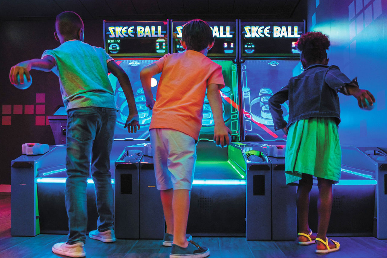 Kids Trying to Beat the High Score on Skeeball