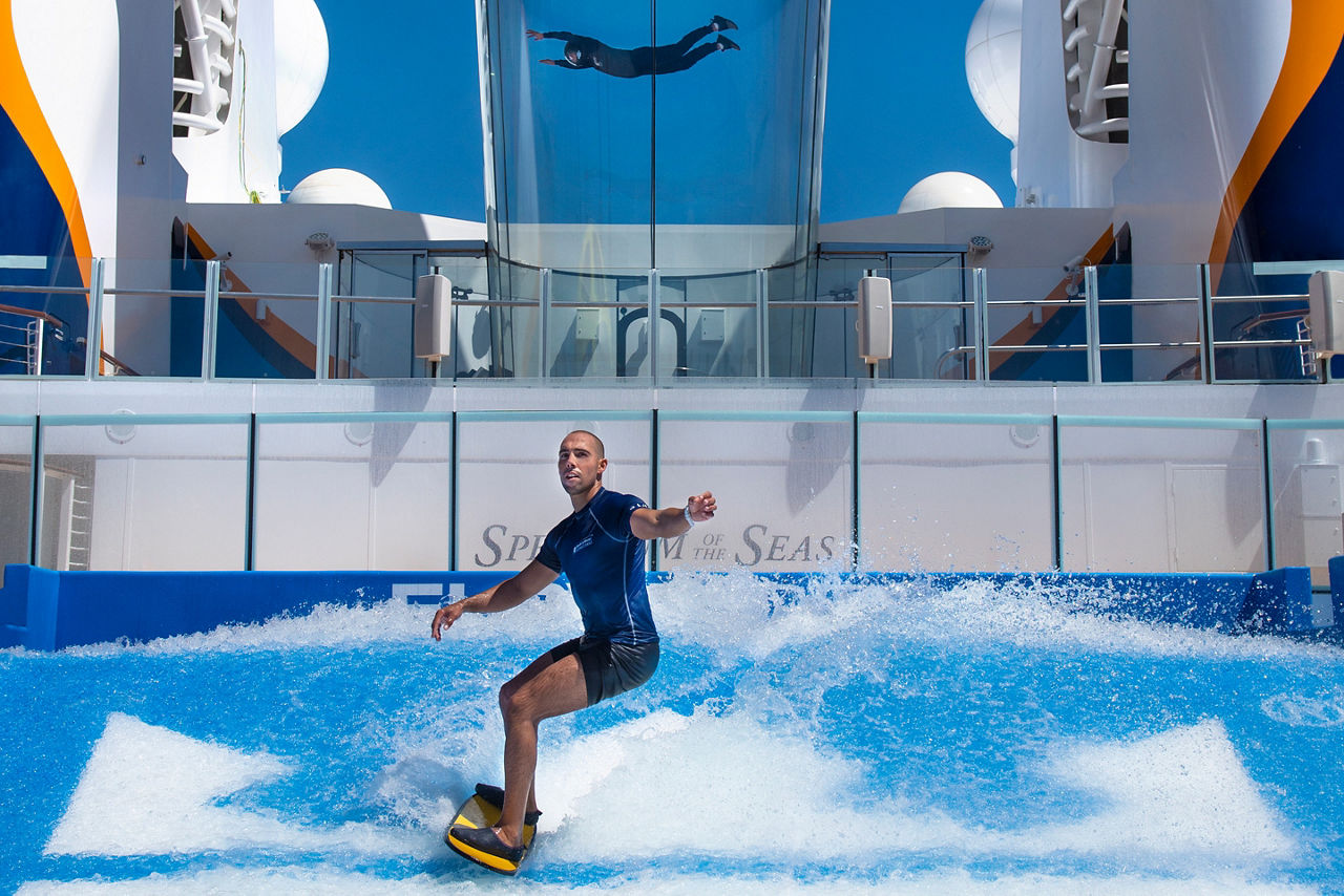 Man Surfing on Flowrider with Man Enjoy Ripcord in the Background
