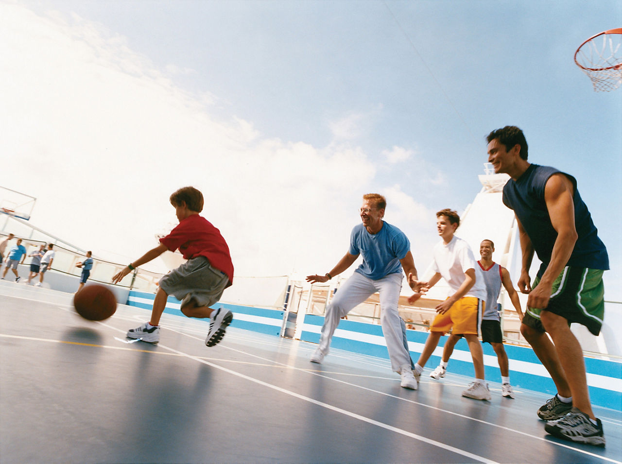 Men and Kids Enjoying a Game of Basketball on the Sports Court 