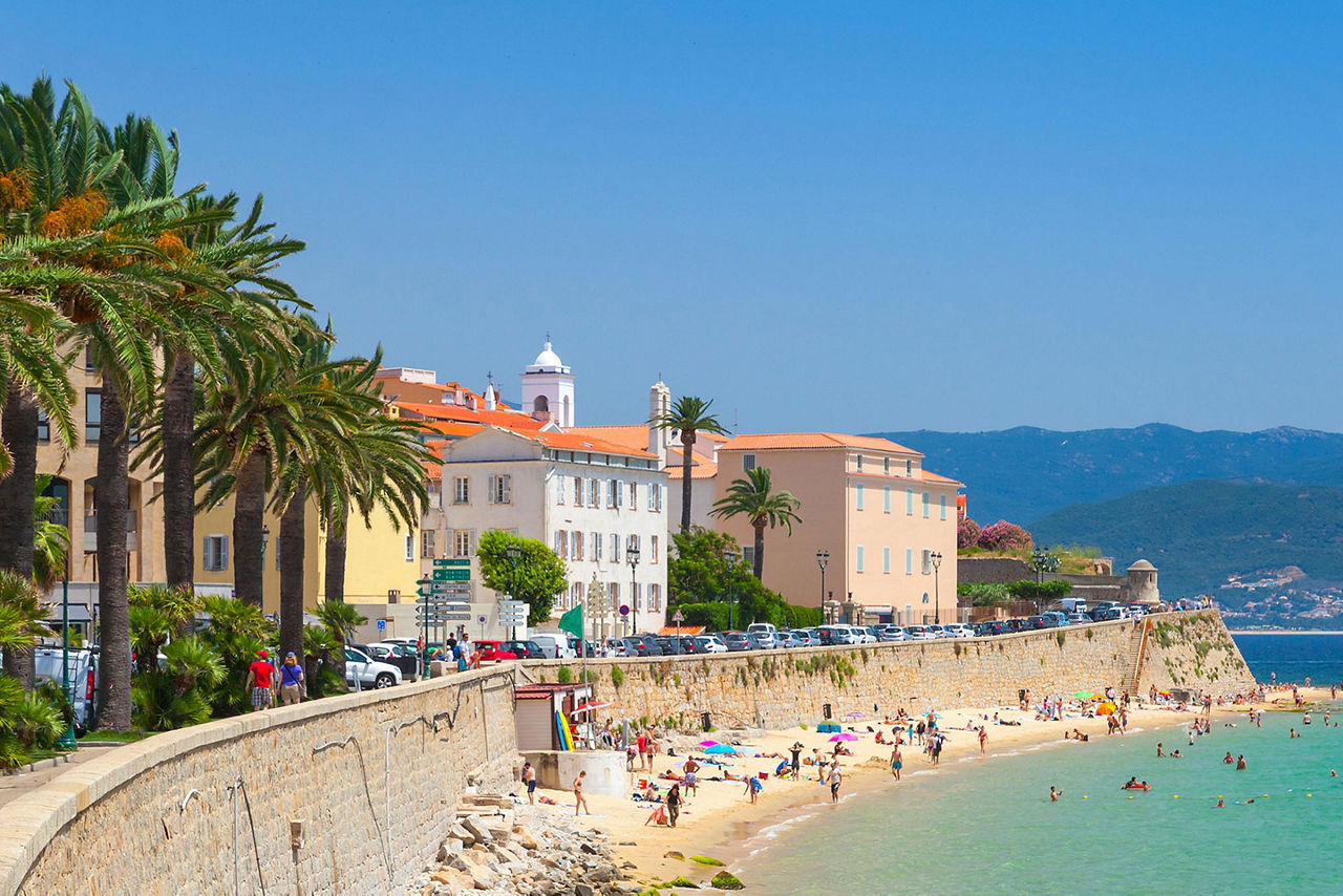 People enjoying the beach at the sea wall in Ajaccio, Corsica