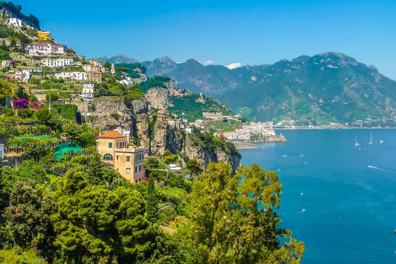 Homes lining a lush green mountain in the Amalfi Coast