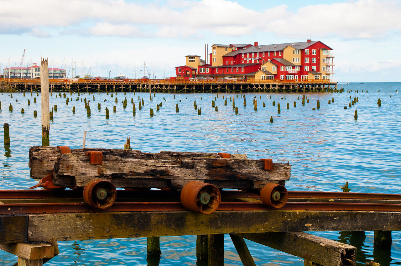 A rusted rail cart with the Cannery Pier in the distance