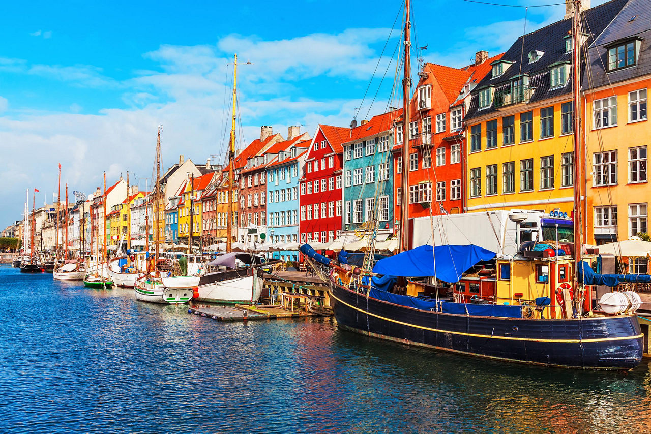 Scenic Summer sunset view of Nyhavn pier with color buildings, ships, yachts and other boats in the Old Town of Copenhagen, Denmark