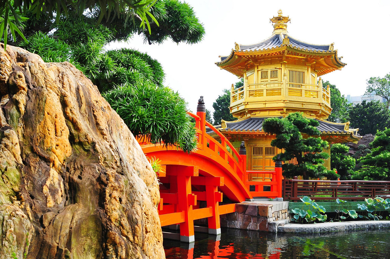 A red bridge leading to a temple Chinese architecture in a garden in Hong Kong, China