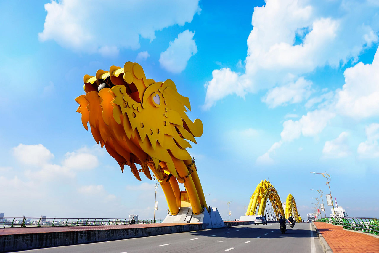 A yellow giant dragon bridge on a beautiful cloudy day in Vietnam