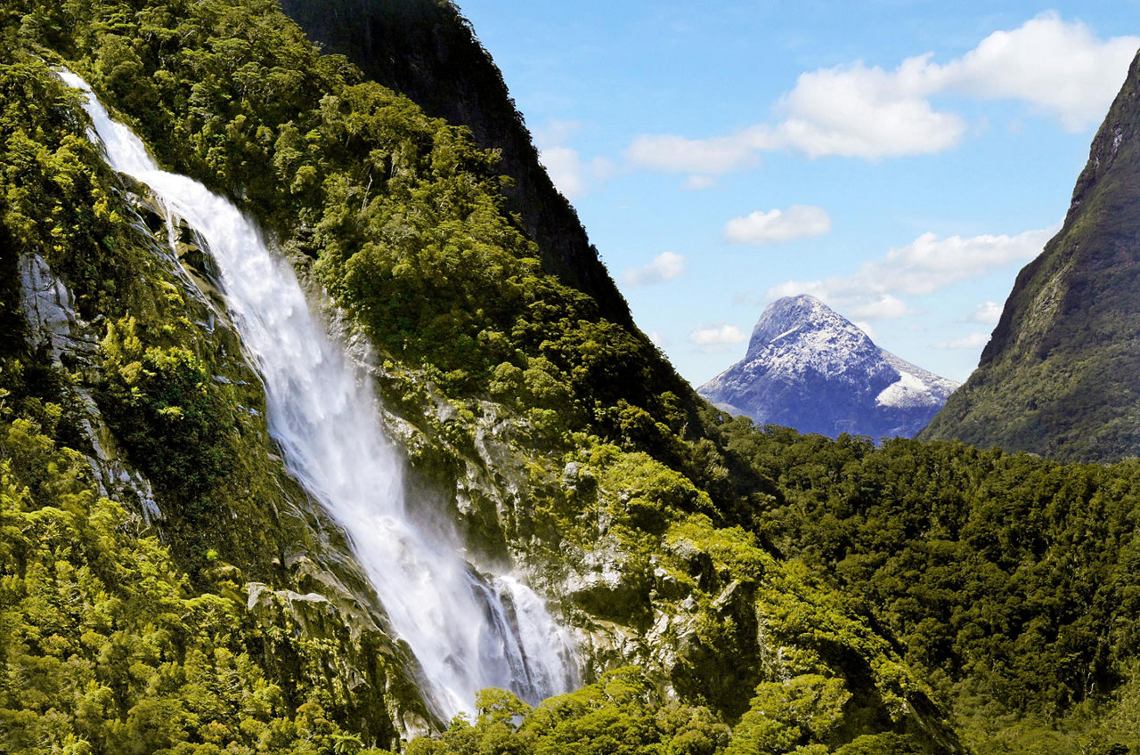 Waterfall cascading down the mountains in Milford Sound, New Zealand