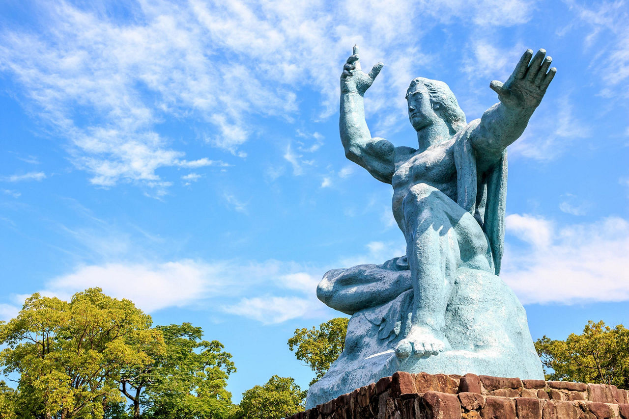 The Peace Statue of a man with his hands up while sitting found in the Nagasaki Peace Park in Japan