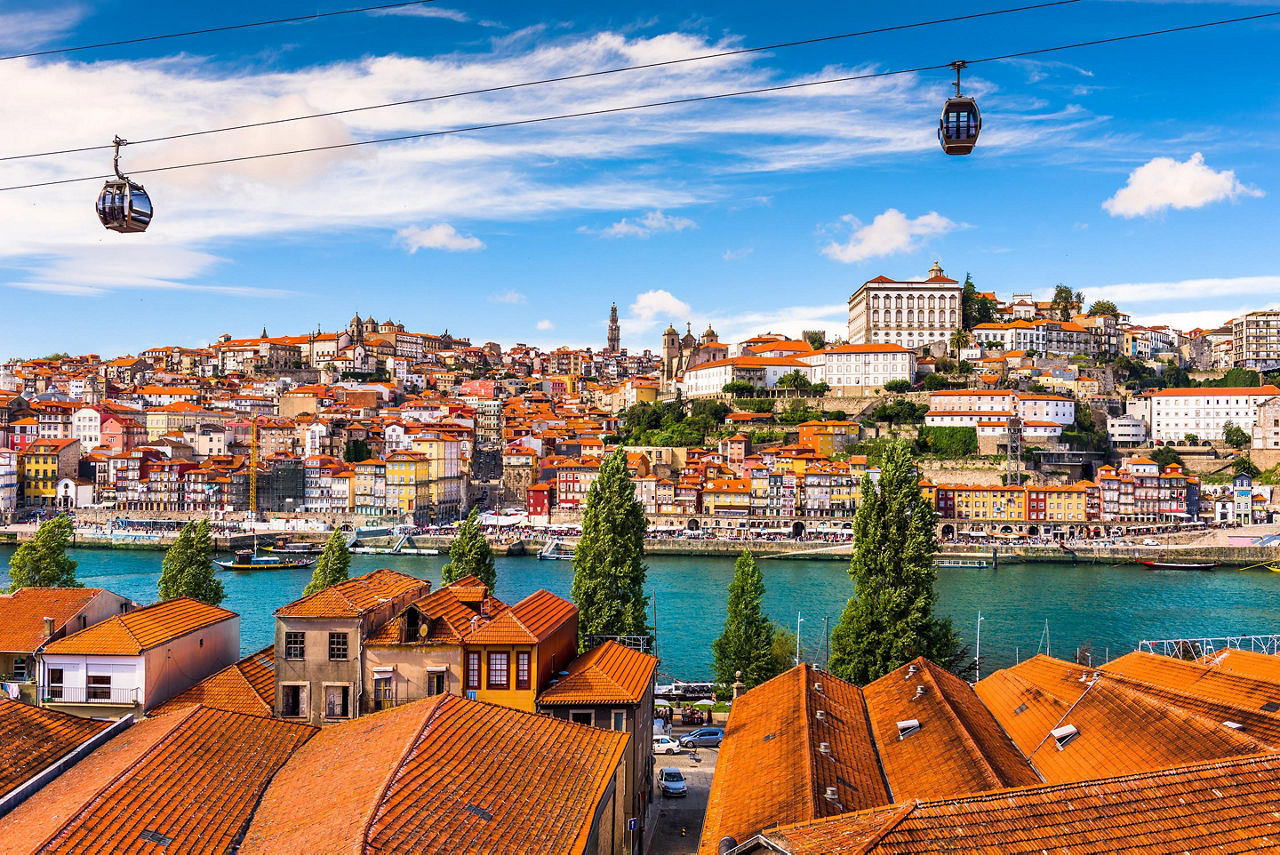 Two gondolas moving along Duoro river against the cityscape of old town Porto, Portugal