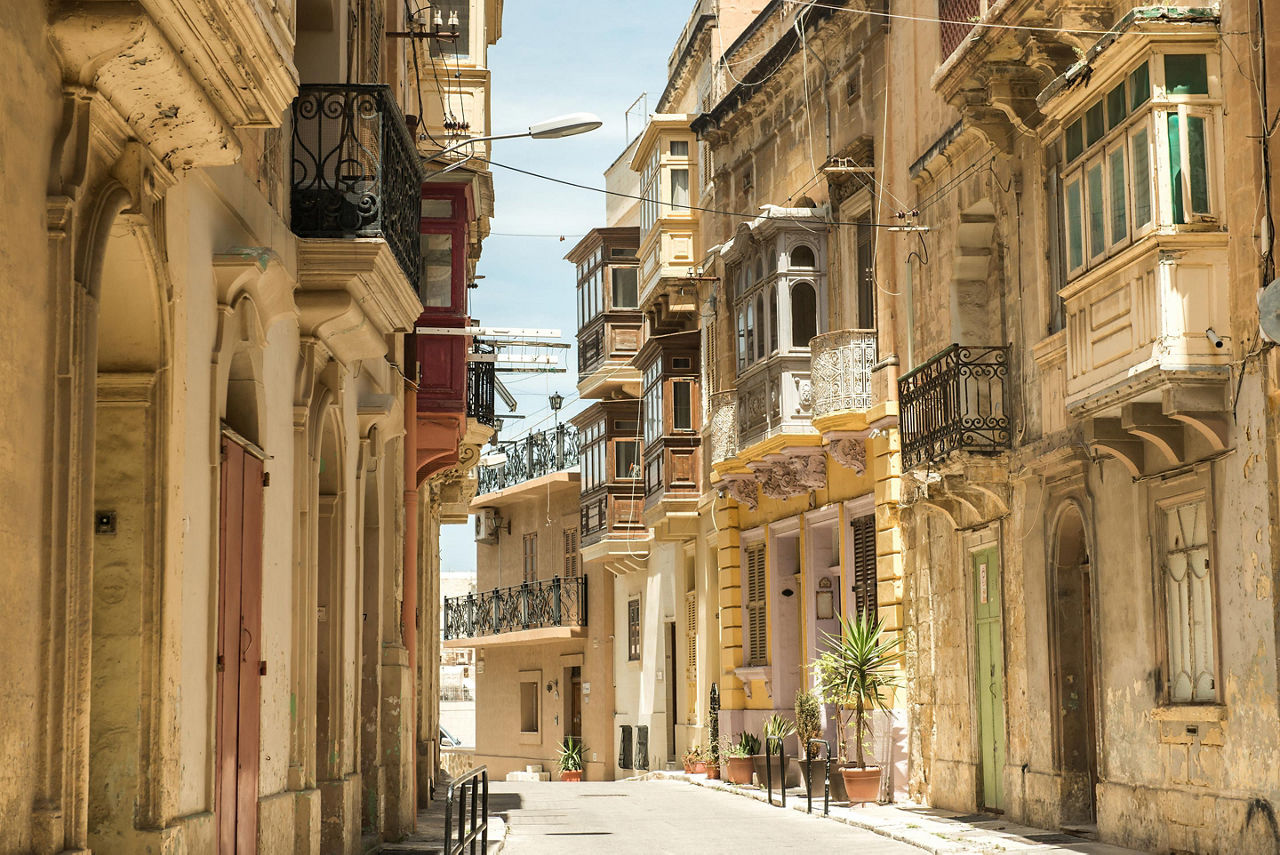 Narrow street with traditional balconies in Valletta, Malta