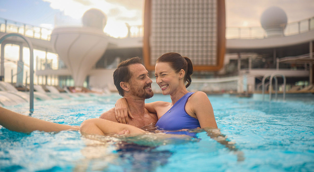 couple in celebrity apex main deck pool 2560x1440