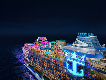 Legend of the Seas, nuova nave da crociera Royal Caribbean vista dall'alto illuminata durante una navigazione notturna. Scopri le crociere a bordo di Legend of the Seas.