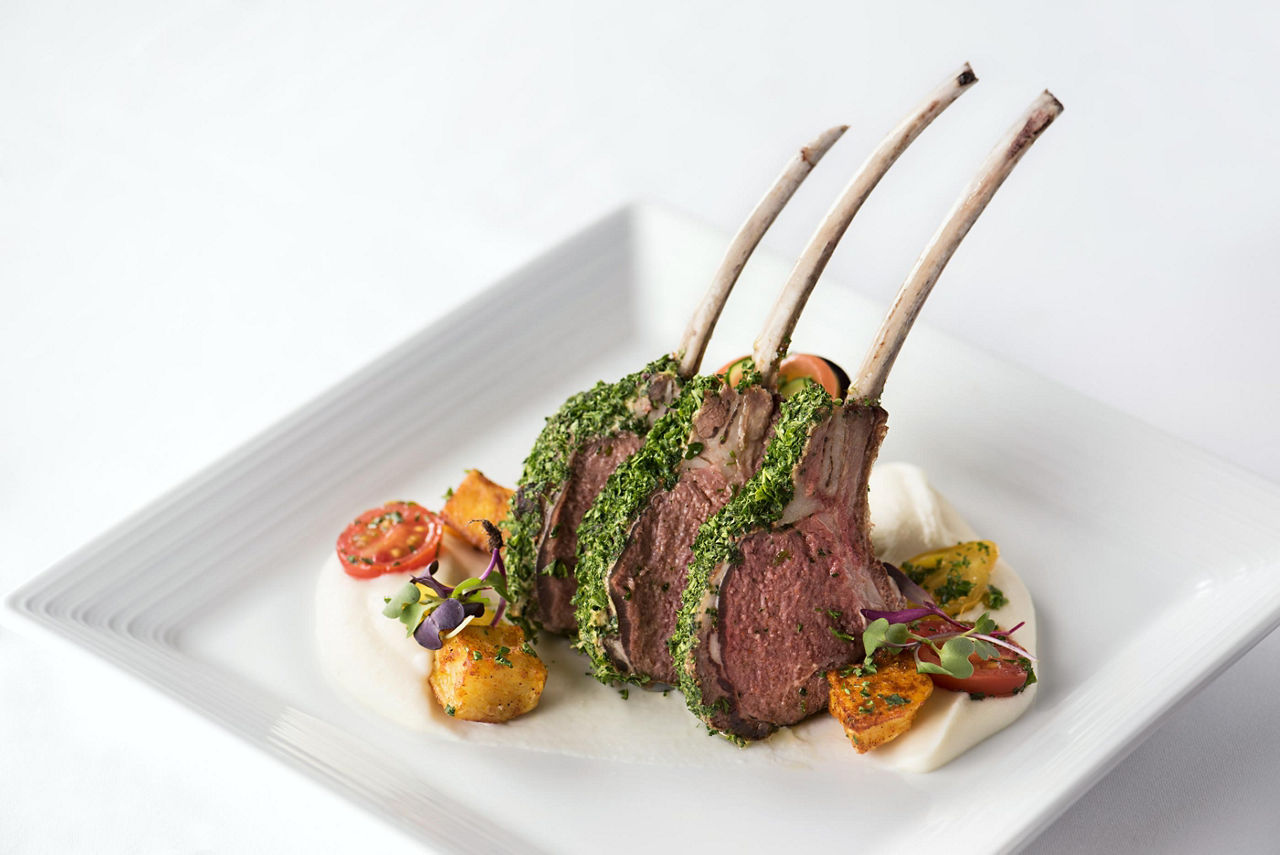 A white plate with three lab ribs at the Main Dining Room