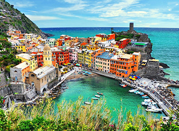 Pittoresco villaggio costiero del Mediterraneo con case affacciate sul mare e panorama sul litorale europeo, destinazione ideale per una crociera nel Mediterraneo.