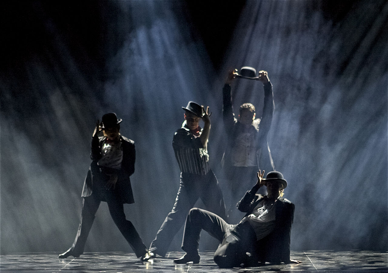 Performers dressed in black on stage during the Marquee Cruise Show