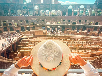 A woman wearing a hat taking a picture in The Colosseum