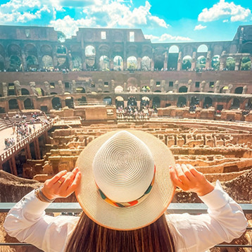 A woman wearing a hat taking a picture in The Colosseum