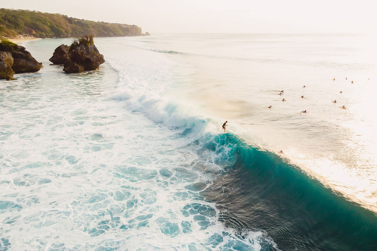 Aerial view with surfers and barrel wave in ocean, Padang Padang, Bali, Indonesia