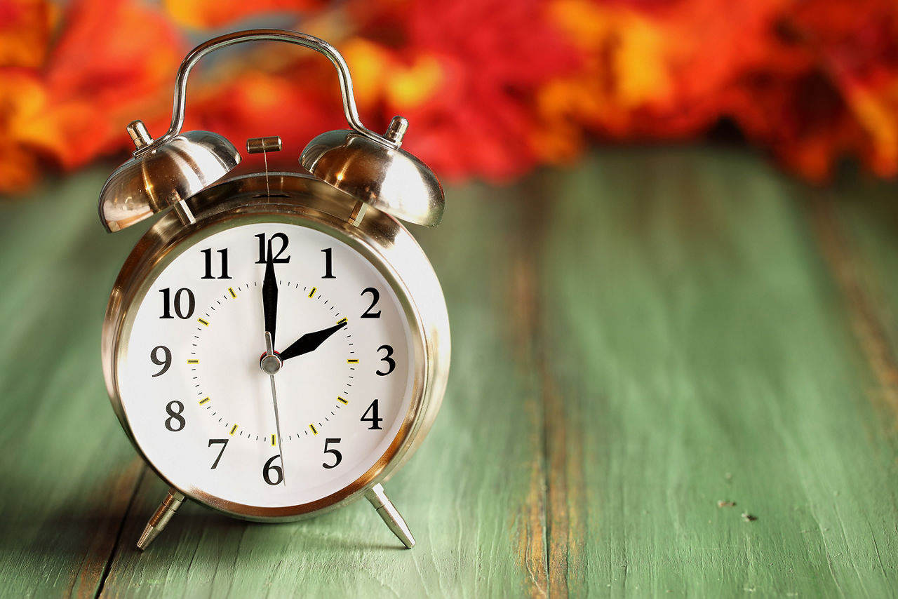 Alarm clock, with fall leaves on the background
