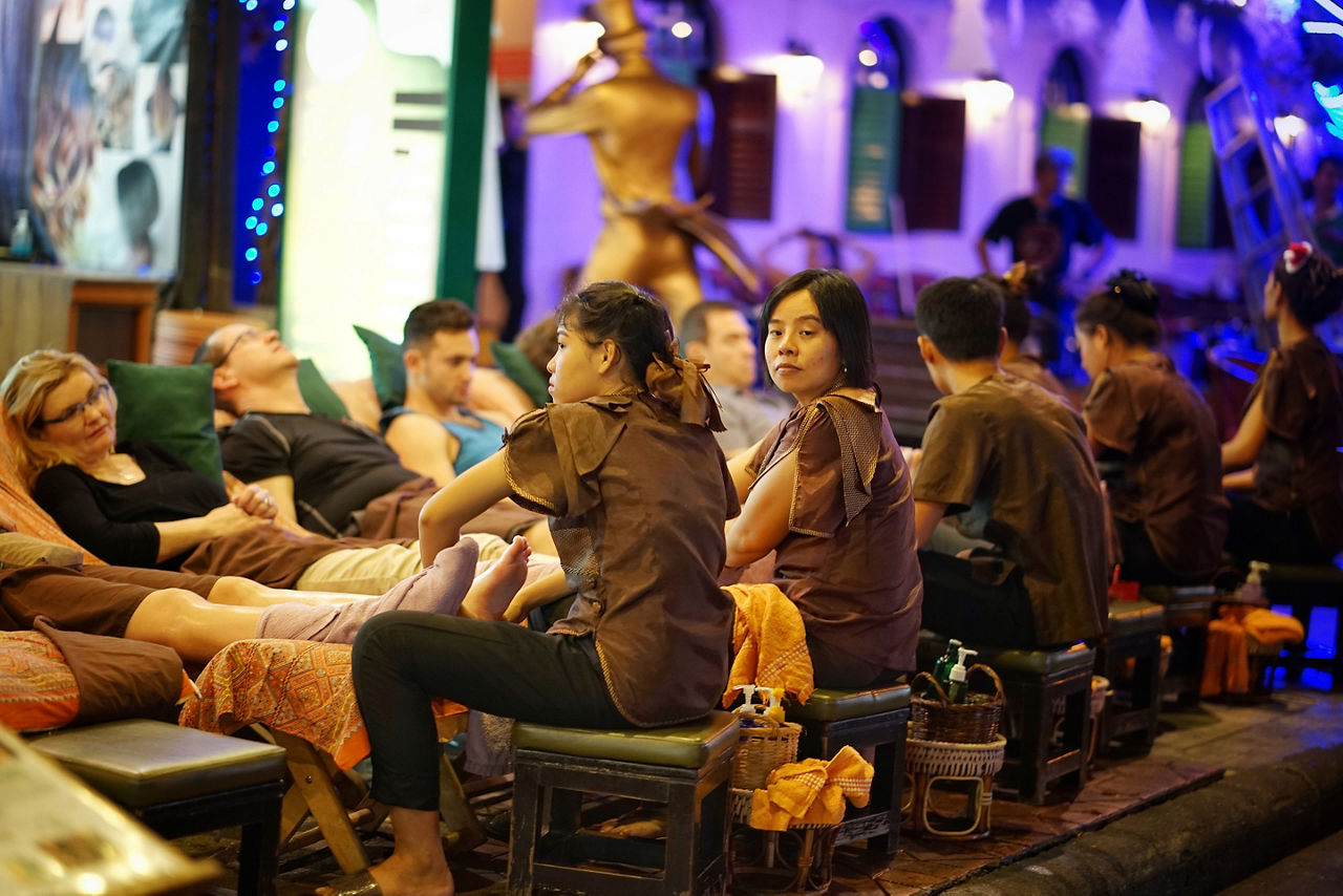 Unidentified massager is massaging  foreign at Khaosan Road , Bangkok, Thailand. Thai massage.