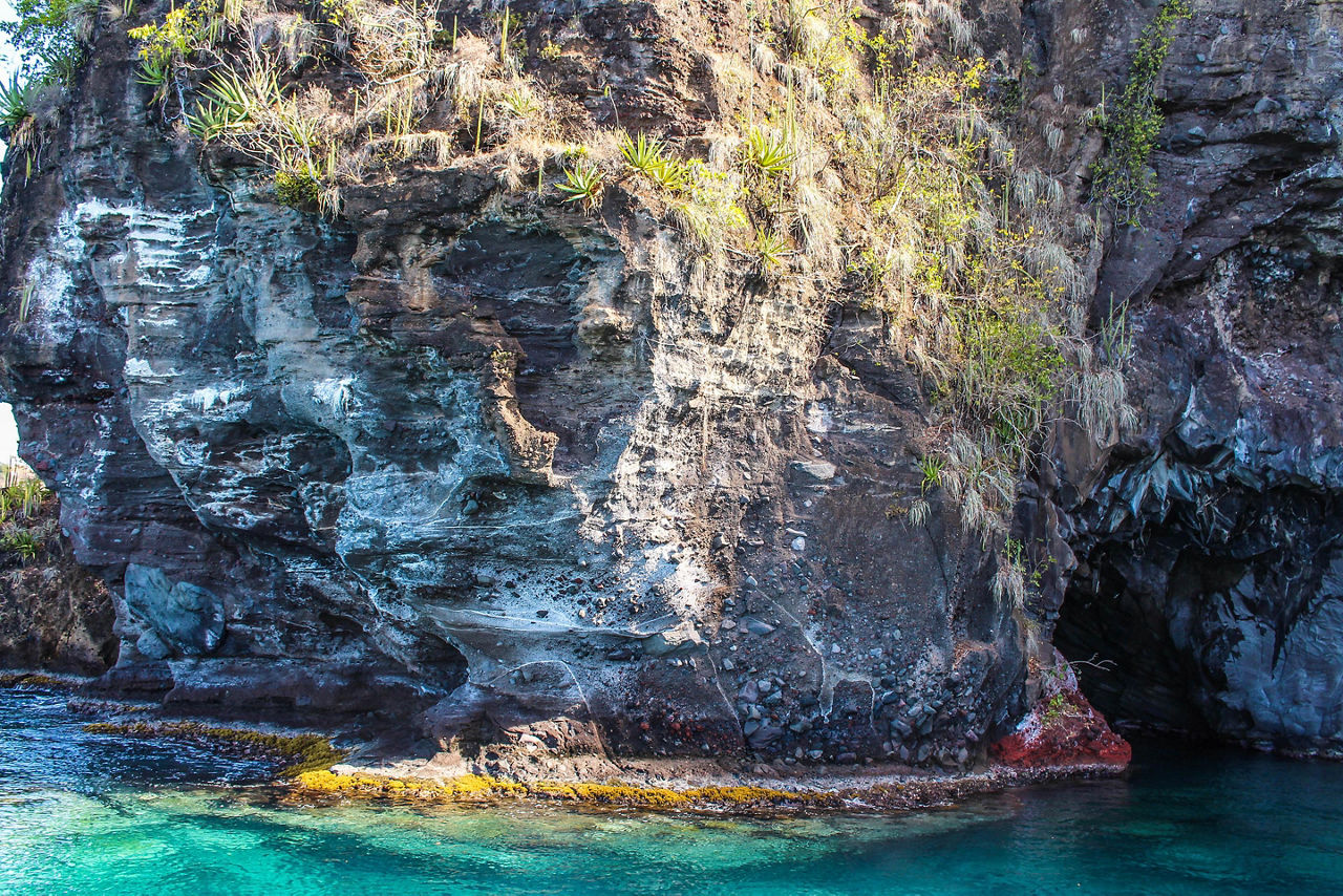 Byahaut bat cave over beautiful turquoise waters with natural rock behind in St Vincent , Caribbean