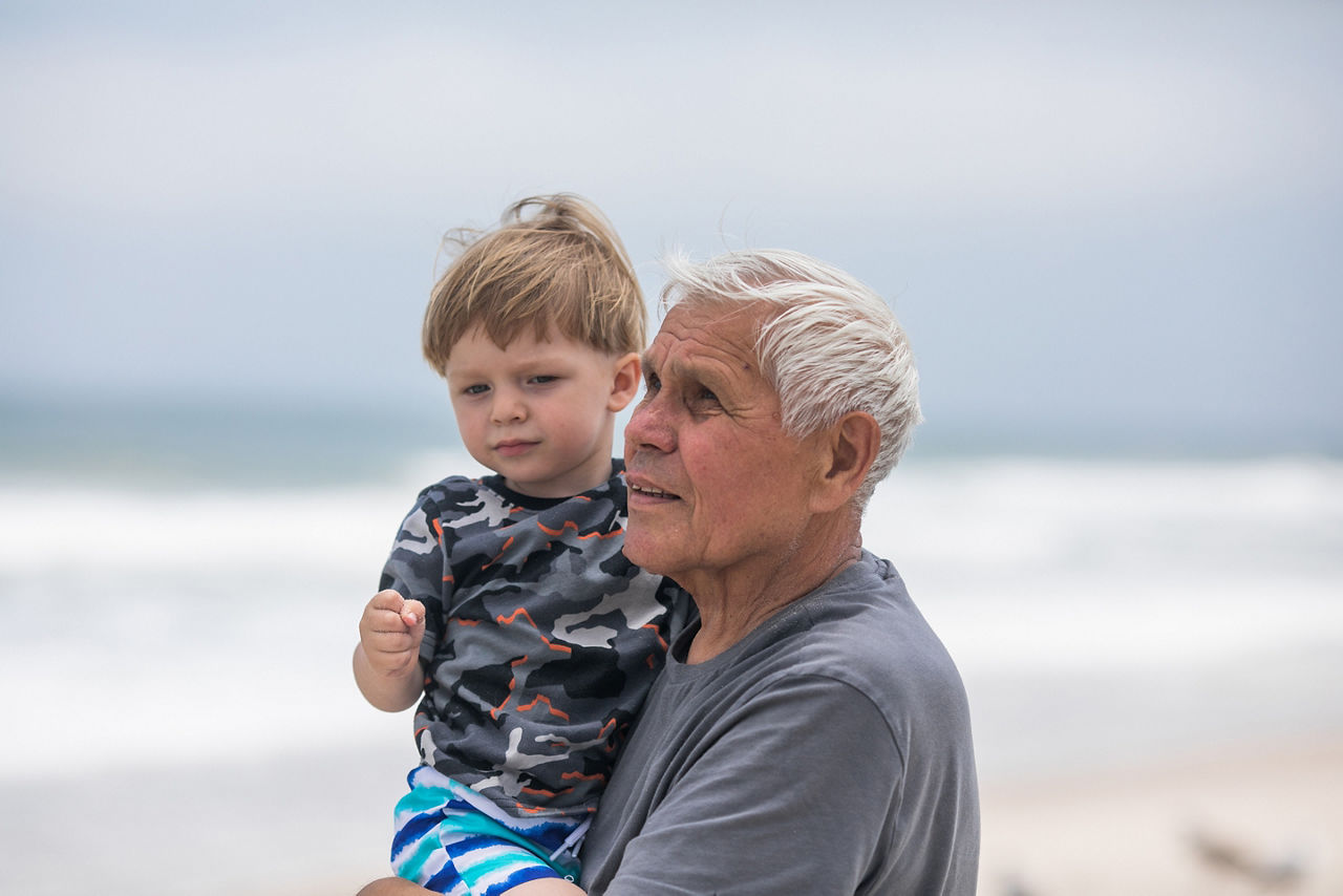 Grandfather spending quality time with his young grandson by the ocean. Gramping.