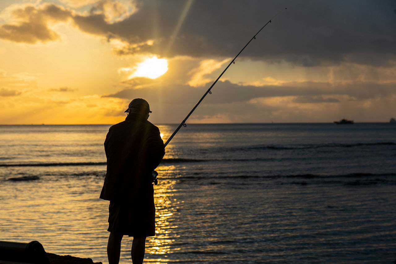 Fishing at Sunset on the shore of Honolulu, Hawaii.