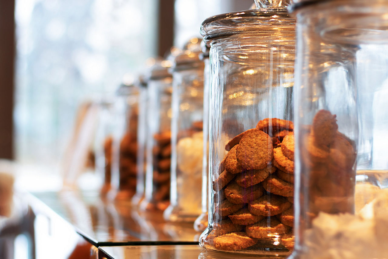 Many glass jars with caps filled with cookies and sweets