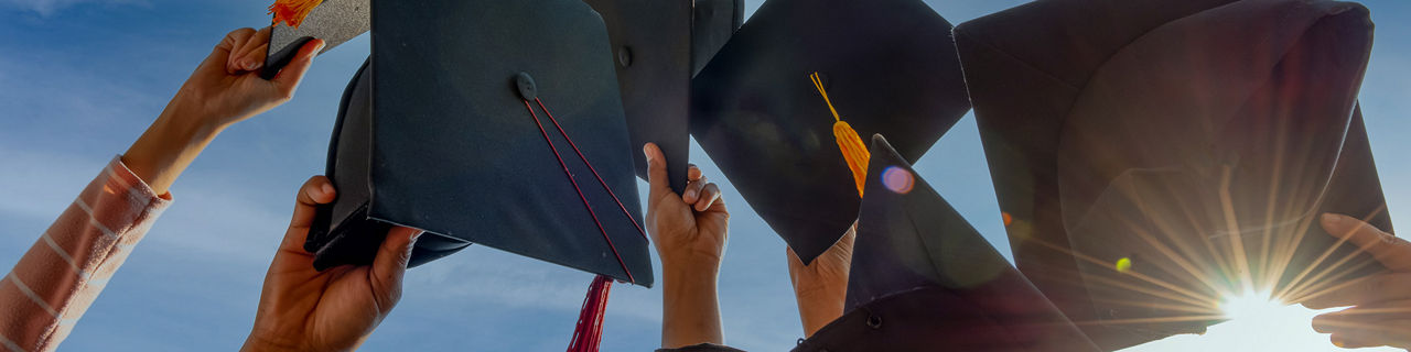 graduates throwing graduation hats up in the sky 1920 480