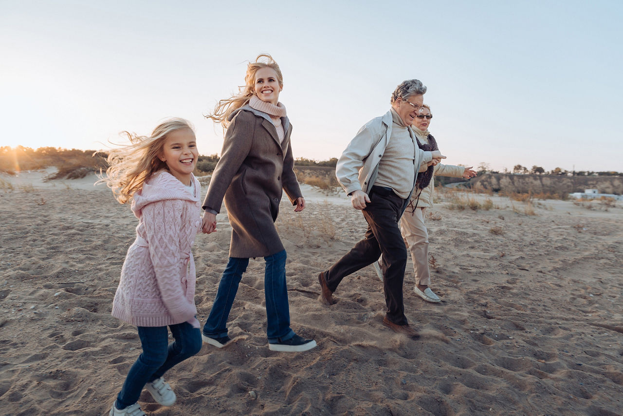 Multigenerational family spending time together and walking on beach.