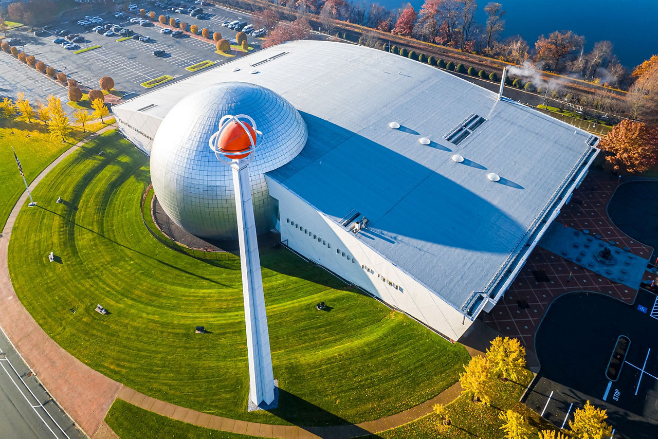 High-angle drone shot of the Naismith Memorial Basketball Hall of Fame with its iconic silver dome and giant basketball sculpture, perfect for sports tourism and architecture themes, Massachusetts
