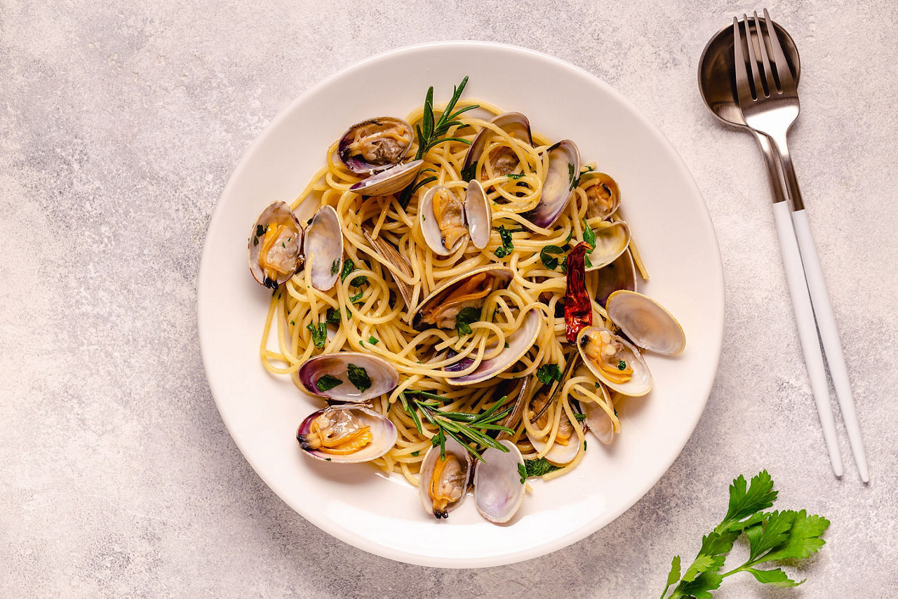 Seafood pasta with clams Spaghetti alle Vongole on a light background. Top view
