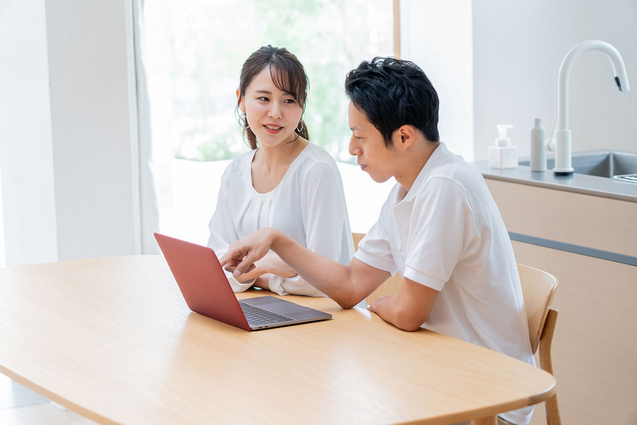Young Asian couple thinking in front of a computer