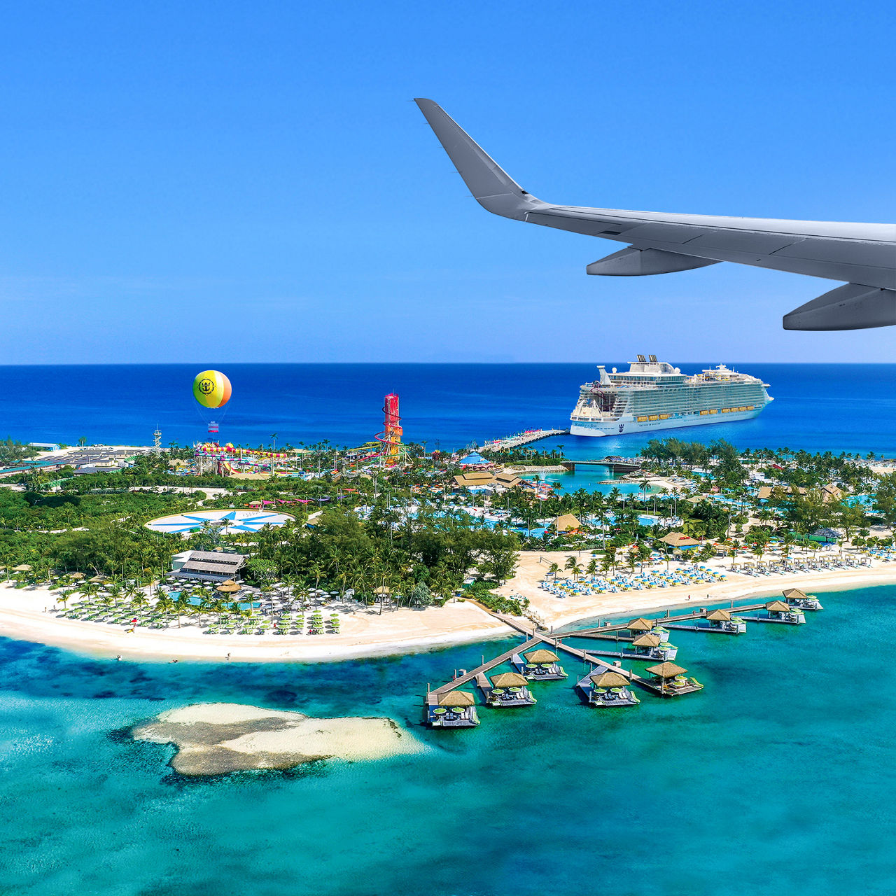 Aerial of Perfect Day CocoCay. Ship and hot air baloon in the background. Plane wing visible.