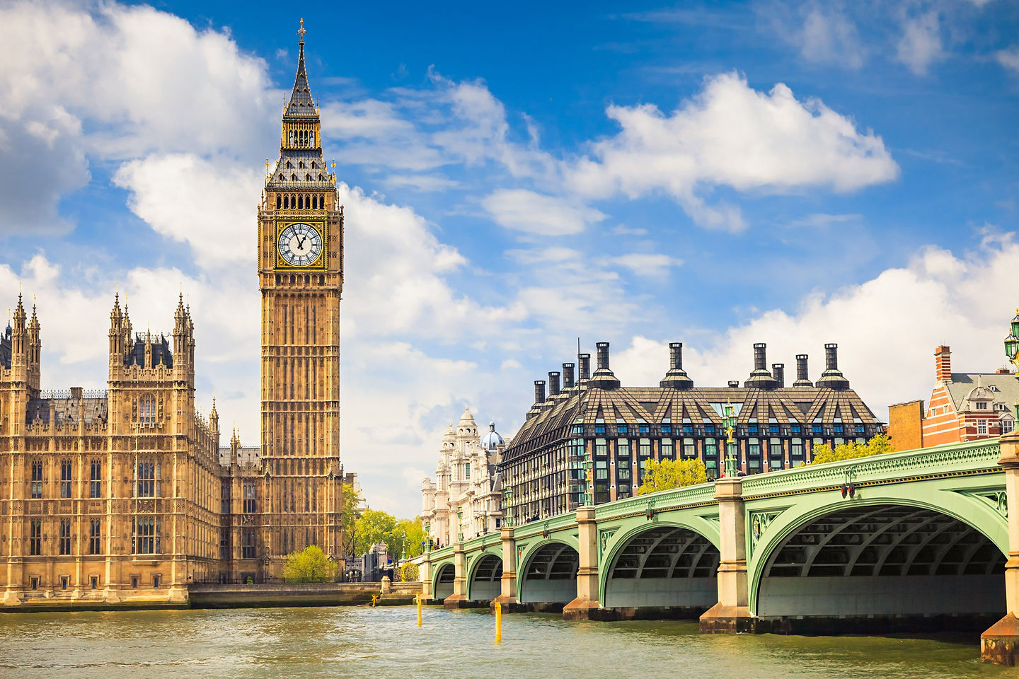Big Ben and Westminster Bridge rise over the Thames beneath clear, bright London daylight. - London, England