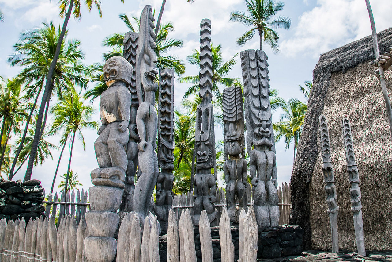 Ancient Polynesian style tiki wooden carvings greet visitors to Ki'i Pu'uhonua O Honaunau National Park on the Big Island of Hawaii