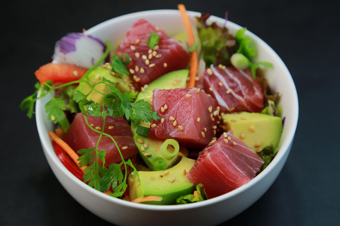 Ahi tuna poke is served in a bowl with fresh toppings and bright Hawaiian flavors. - Honolulu, Hawaii