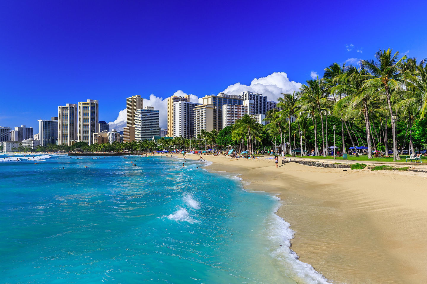 Honolulu skyline rising behind a sunny Waikiki beach. - Honolulu, Hawaii
