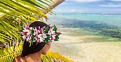 Hawaii beach woman luau dancer relaxing wearing wreath of fresh flowers on Tahiti Bora Bora, French Polynesia.
