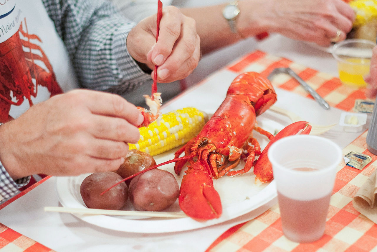Man Eating New England clambake with lobster