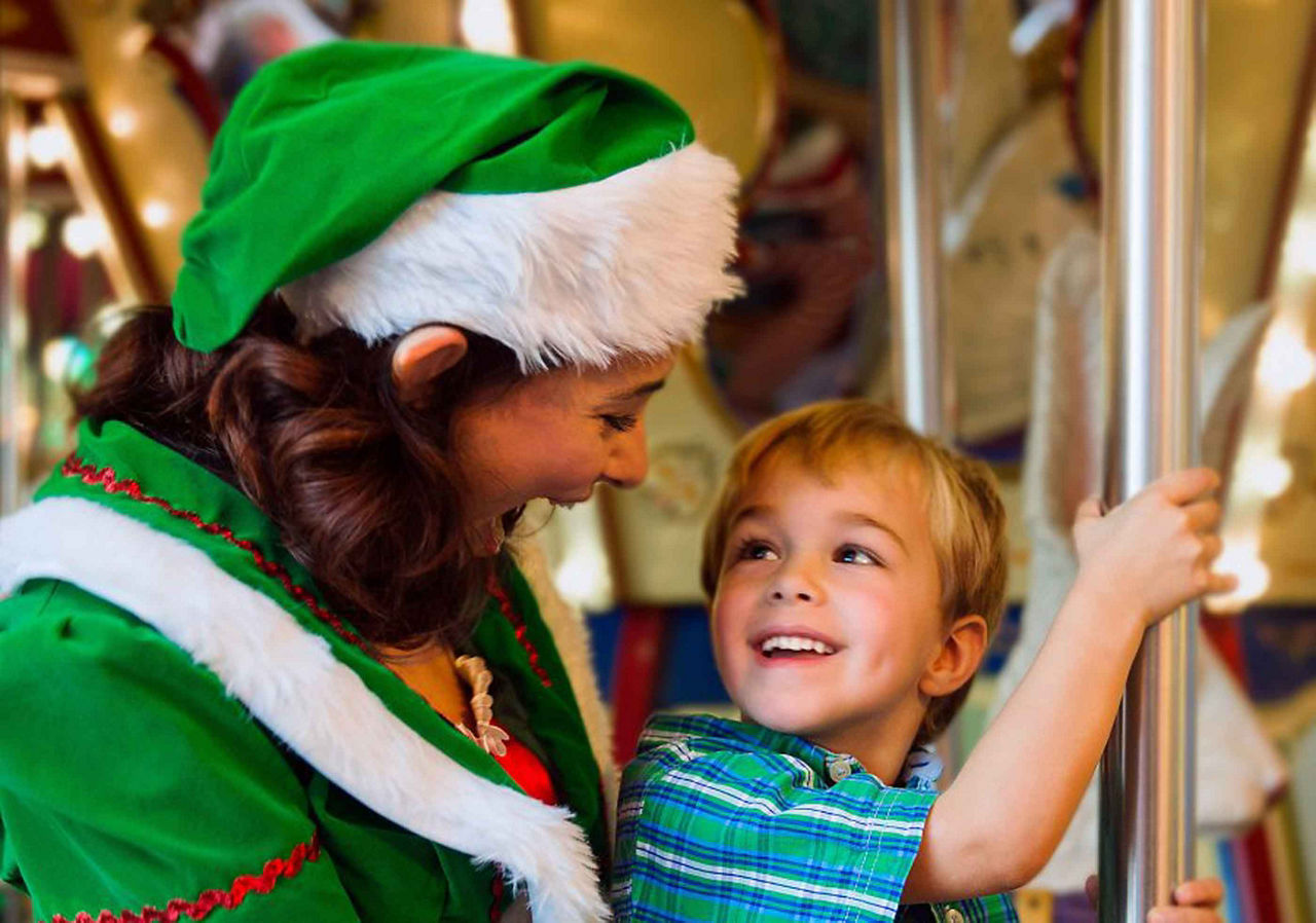 Christmas Elf Riding on the Carousel with a Little Kid