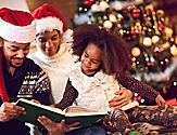 Family wearing Santa Hats Reading a Story with Christmas Tree in the Background