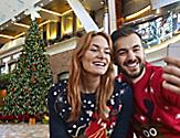 Couple Taking a Selfie with a Christmas Tree in the Background as part of the Holiday Cruise Experience