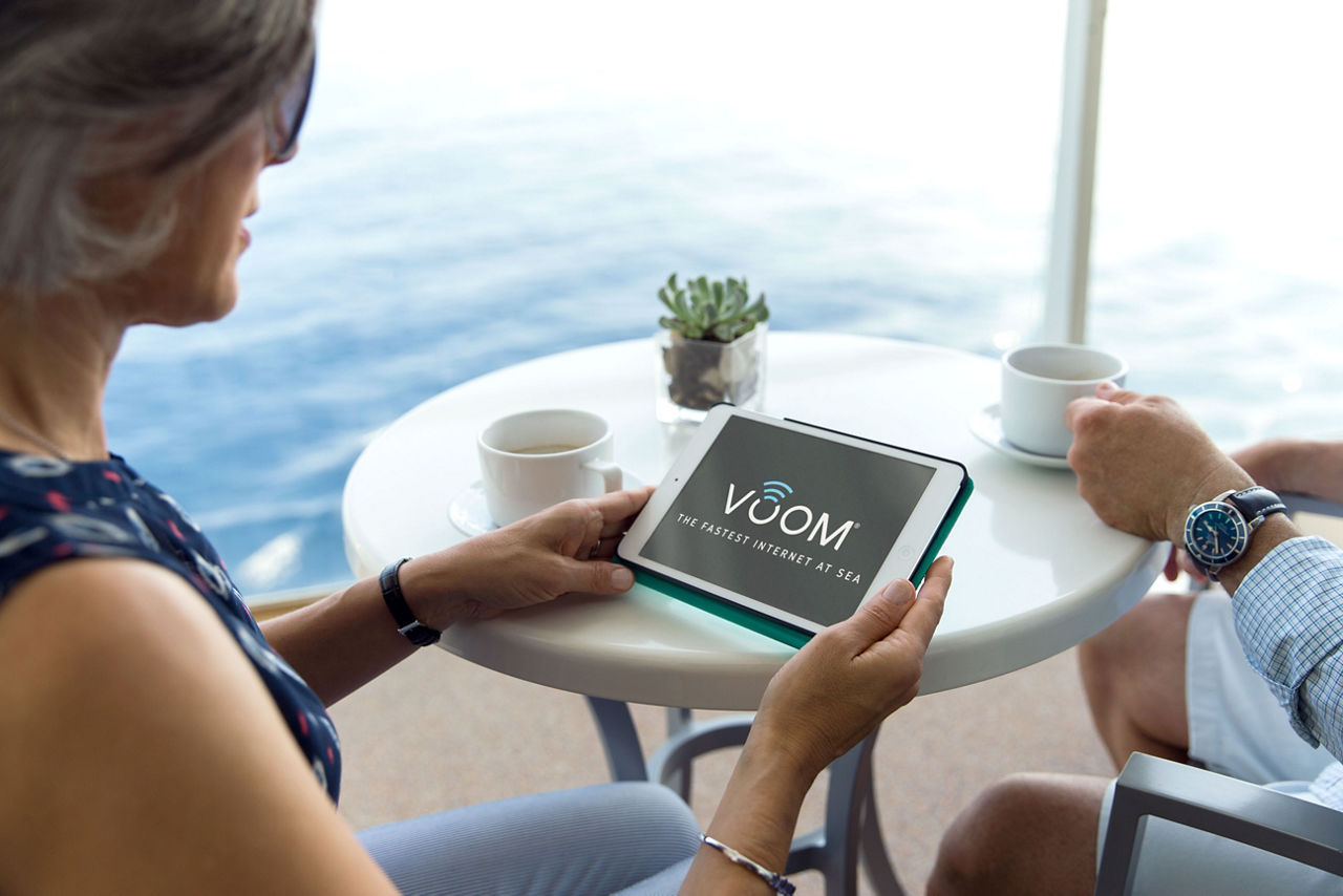 Woman Holding A Device with the Fastest Cruise Wifi at Sea, Voom