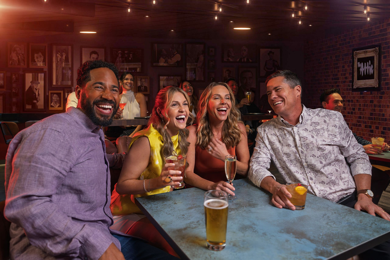 Friends drinking and laughing at a bar