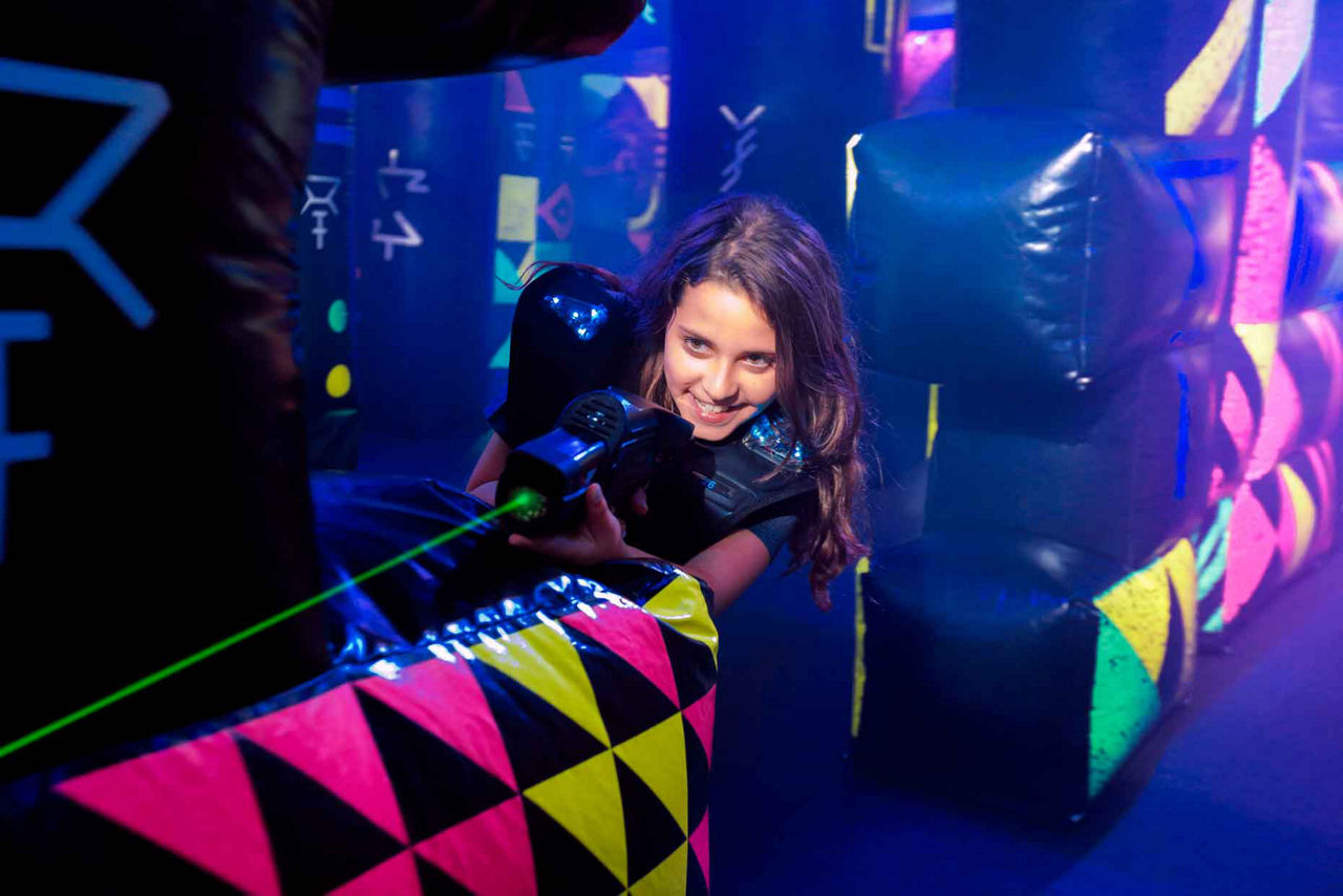 A girl aiming her laser at another player while playing laser tag onboard a cruise ship