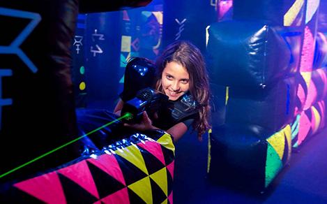 A girl aiming her laser at another player while playing laser tag onboard a cruise ship