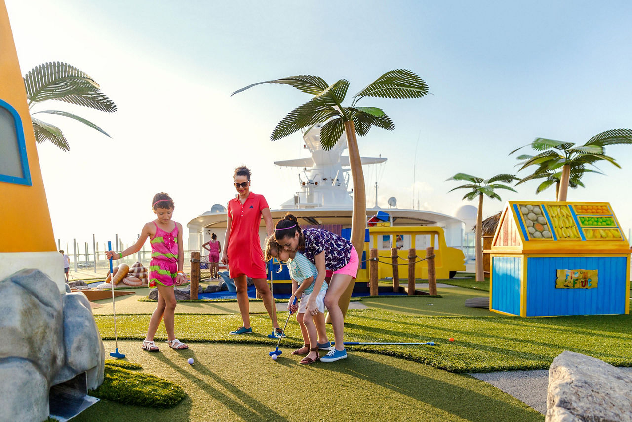 Sister Teaching Younger Brother Mini Golf