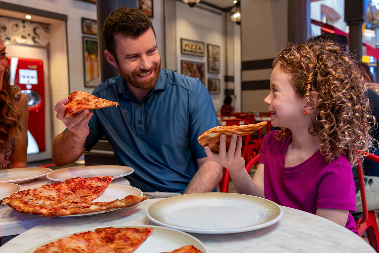 Dad and daughter having a slice of pizza at Sorrentos